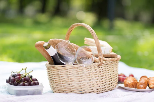 Picnic basket, food and wine at summer park — Stock Photo, Image