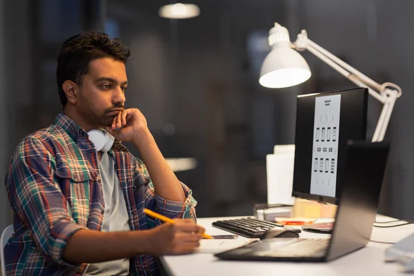 Creative man with laptop working at night office — Stock Photo, Image