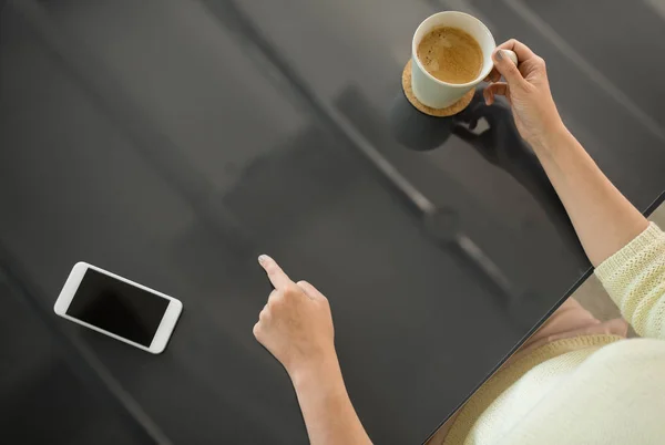 Mujer con café usando panel interactivo negro — Foto de Stock