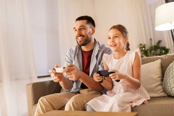 Father and daughter playing video game at home — Stock Photo, Image