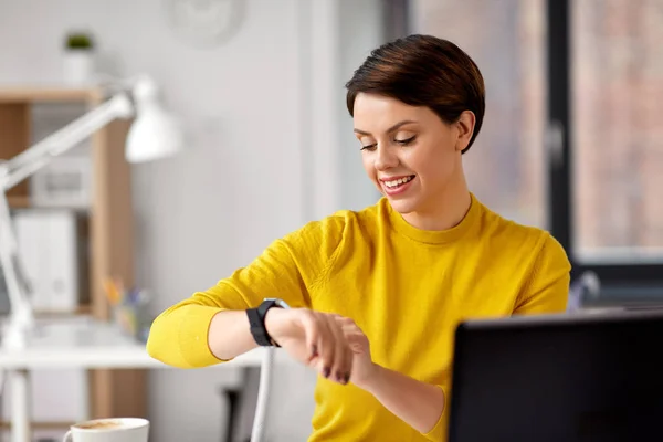 Zufriedene Geschäftsfrau mit Smart Watch im Büro — Stockfoto