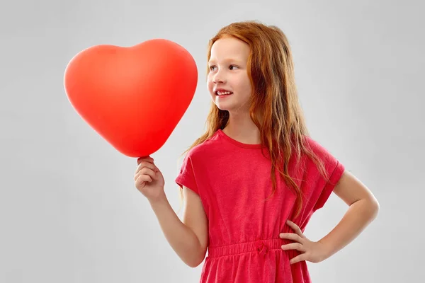 Sorrindo menina de cabelos vermelhos com balão em forma de coração — Fotografia de Stock