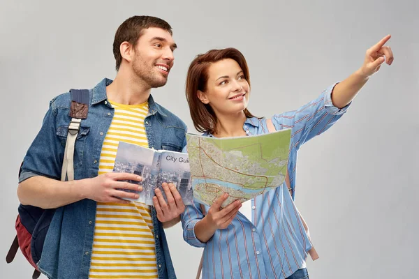 Happy couple of tourists with city guide and map — Stock Photo, Image