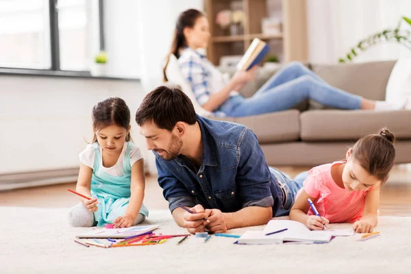 Vader met kleine dochters tekenen thuis — Stockfoto