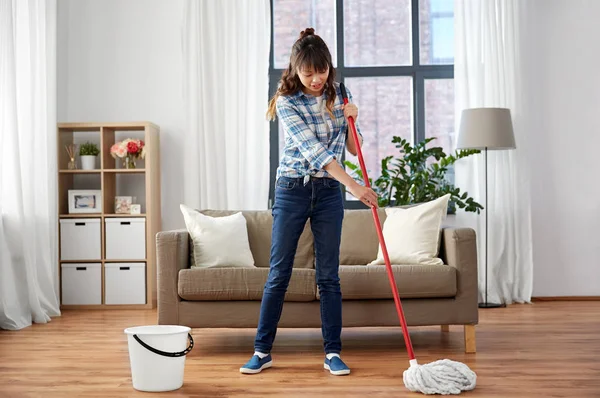 Feliz mulher asiática com esfregão limpeza chão em casa — Fotografia de Stock
