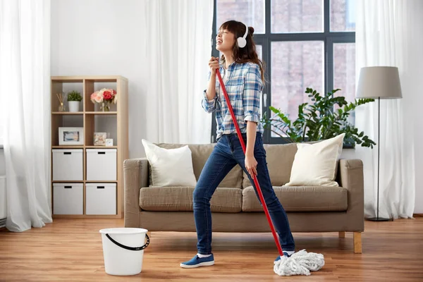 Gelukkige Aziatische vrouw met MOP schoonmaak vloer thuis — Stockfoto