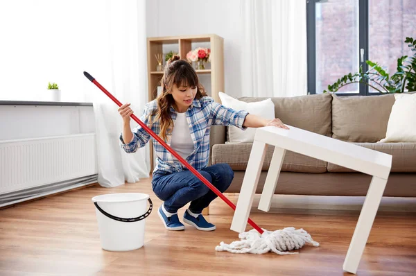 Evde paspas temizleme zemin ile mutlu asyalı kadın — Stok fotoğraf