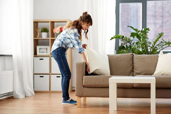 Mujer asiática arreglando cojines de sofá en casa — Foto de Stock