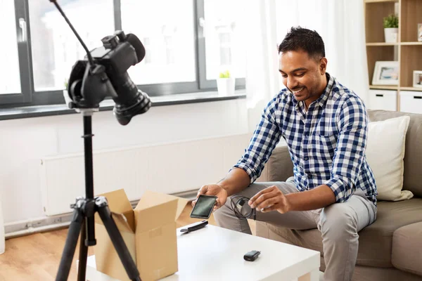 Blogger masculino con smartphone, cable y caja de paquetes — Foto de Stock