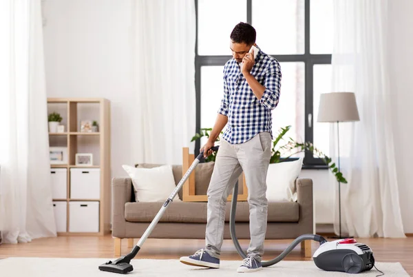 Pria dengan vacuum cleaner menelepon di rumah — Stok Foto