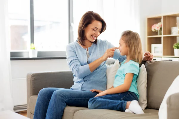 Madre e hija sentadas en el sofá en casa — Foto de Stock