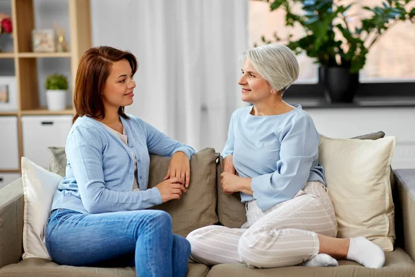 Senior moeder praat met volwassen dochter thuis — Stockfoto