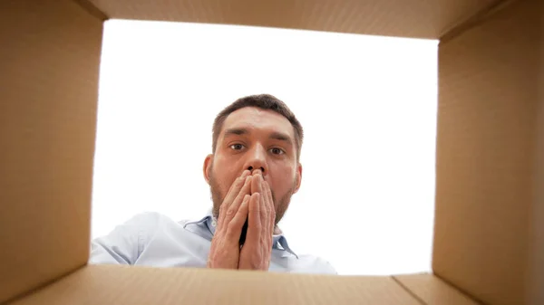 Geschokt man op zoek naar open pakjes doos — Stockfoto