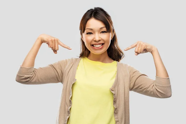 灰色の背景を持つ幸せなアジアの女性 — ストック写真