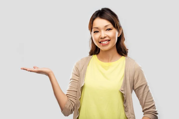 Felice donna asiatica tenendo qualcosa a portata di mano — Foto Stock