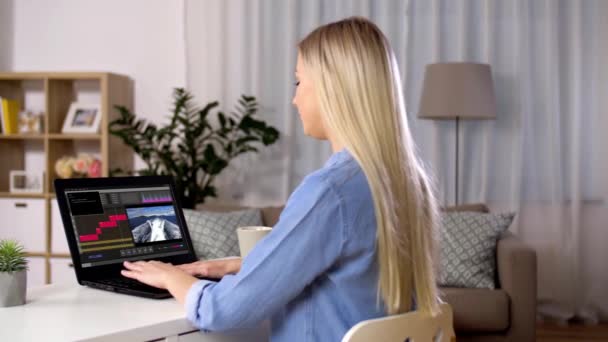 Γυναίκα με πρόγραμμα επεξεργασίας βίντεο στο φορητό υπολογιστή στο σπίτι — Αρχείο Βίντεο