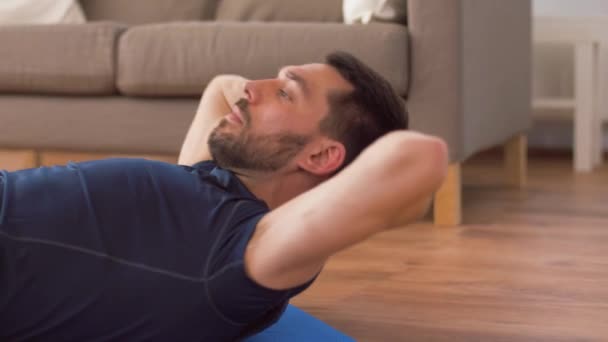 Мужчина делает упражнения на животе дома — стоковое видео