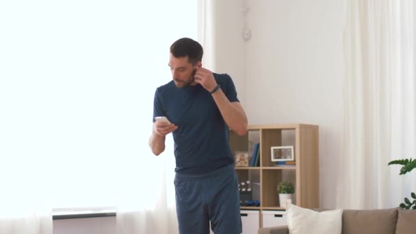 Evde egzersiz kablosuz kulaklık ile adam — Stok video