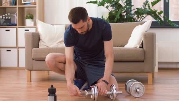 Man assembling dumbbells at home — Stock Video