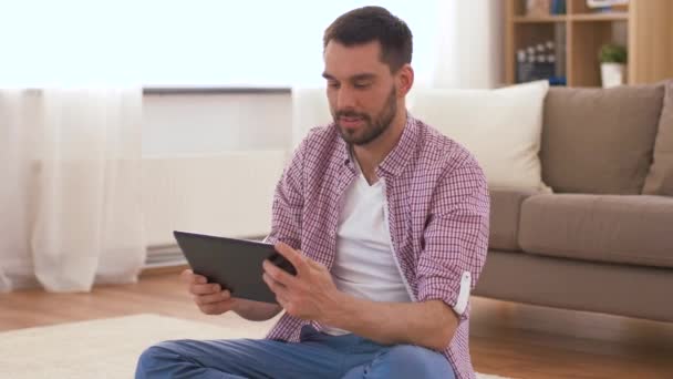 Мужчина с планшетным компьютером медитирует дома — стоковое видео