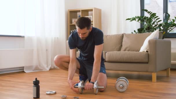 Man assembling dumbbells at home — Stock Video