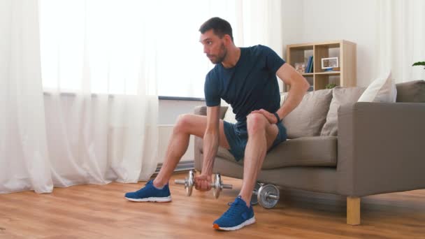 Homem exercitando com halteres em casa — Vídeo de Stock