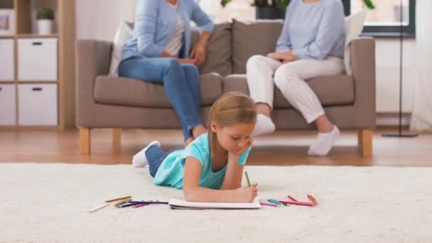 Девушка рисует карандашами в альбоме эскизов дома — стоковое видео