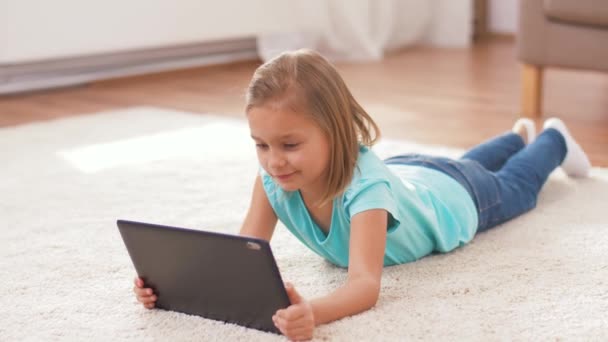 Fille avec tablette d'ordinateur couché sur le sol à la maison — Video