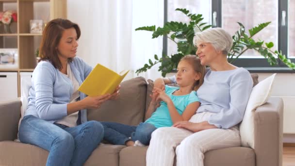 Madre, hija y abuela leyendo libro — Vídeo de stock