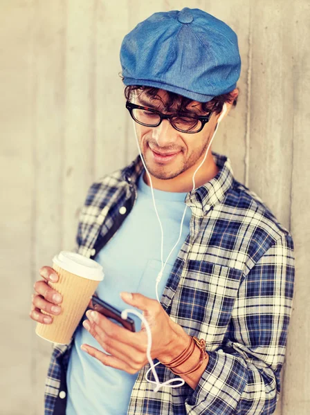 Hombre con auriculares y teléfono inteligente beber café —  Fotos de Stock