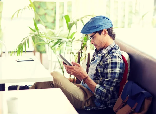 Man met tablet pc zitten aan Cafe tafel — Stockfoto