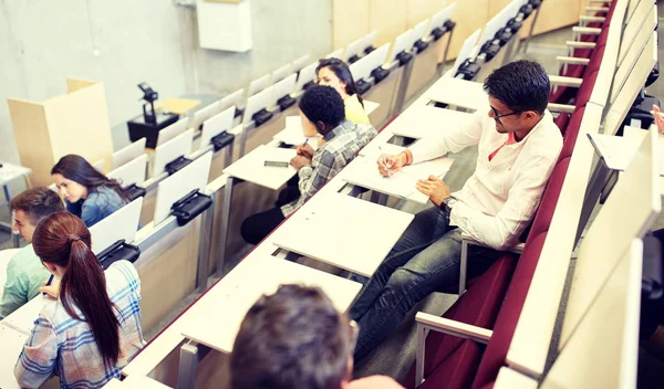 Group of students with notebooks in lecture hall — Stock Photo, Image