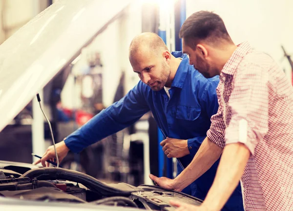 Auto monteur met klembord en man bij de auto-shop — Stockfoto