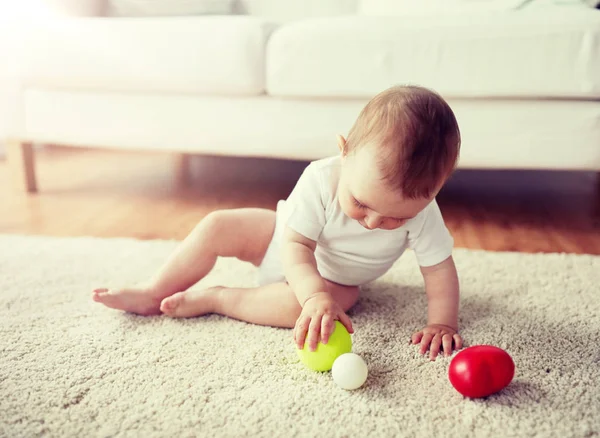 Happy baby spelen met ballen op verdieping thuis — Stockfoto