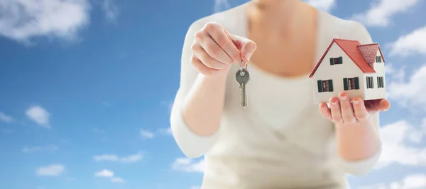 Close up de mãos segurando modelo de casa e chaves — Fotografia de Stock