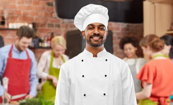 Happy male indian chef in toque at cooking class — Stock Photo, Image