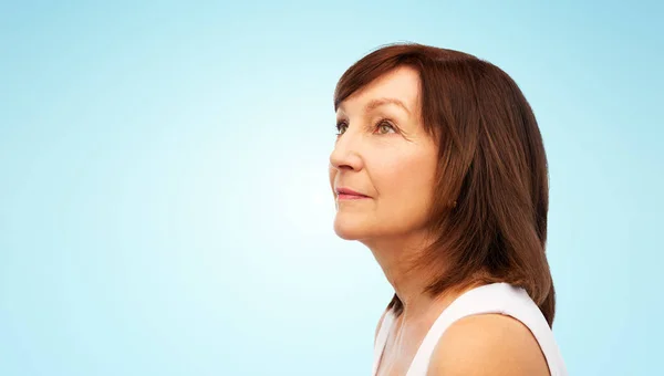 Retrato de mujer mayor sobre fondo azul — Foto de Stock