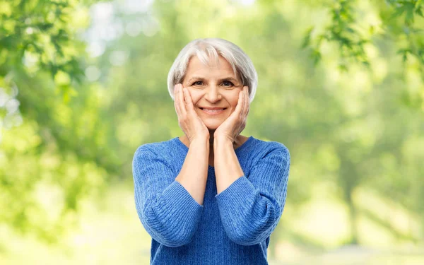 Portrait of smiling senior woman in blue sweater — Stock Photo, Image