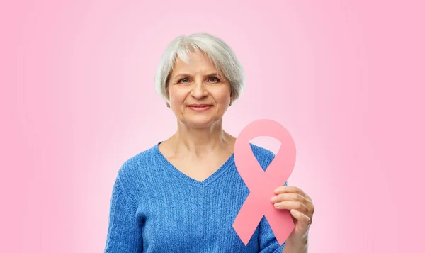 Mulher velha com fita de consciência de câncer de mama rosa — Fotografia de Stock