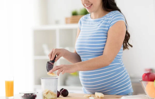 Zwangere vrouw hakken fruit thuis keuken — Stockfoto