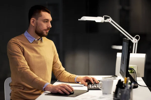 Hombre con computadora trabajando hasta tarde en la oficina nocturna —  Fotos de Stock