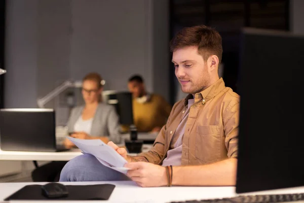 Man with papers working at night office — Stock Photo, Image
