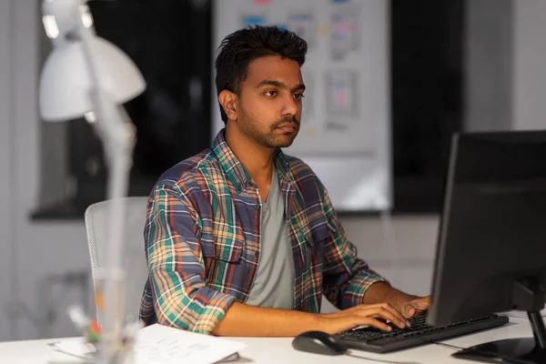 Hombre creativo con computadora trabajando en la oficina nocturna —  Fotos de Stock