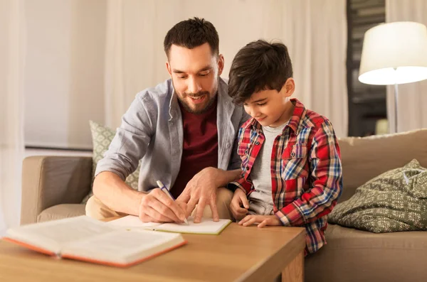Padre e hijo haciendo los deberes juntos —  Fotos de Stock
