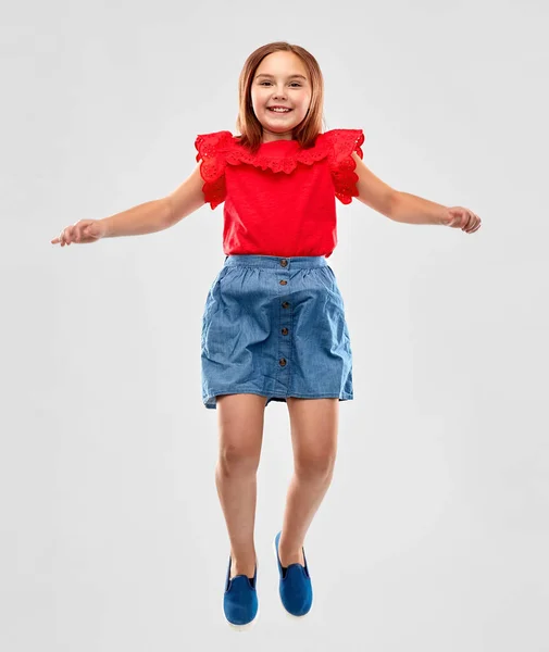 Feliz chica sonriente en camisa roja y falda saltando —  Fotos de Stock