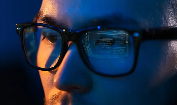 Primer plano de hacker en gafas mirando a la pantalla — Foto de Stock