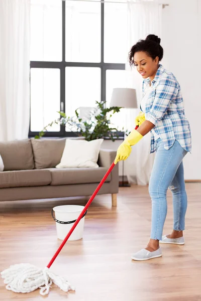 Femme africaine ou femme au foyer nettoyage plancher à la maison — Photo