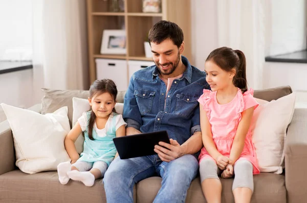 Happy father and daughters with tablet pc at home — Stock Photo, Image