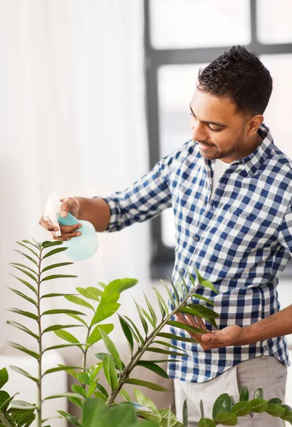 Homme indien pulvérisation plante d'intérieur avec de l'eau à la maison — Photo