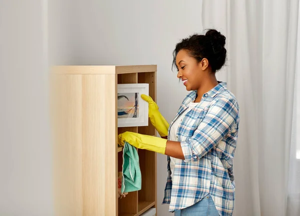 Mujer afroamericana desempolvando y limpiando el hogar —  Fotos de Stock